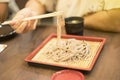 Hand of woman use chopsticks to clamp a noodle on a bamboo dish, japanese noodle, itÃ¢â¬â¢s call Soba, selective focus at noodle Royalty Free Stock Photo